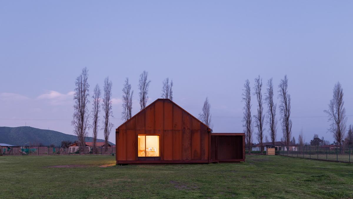 乡村草地上的红色棚屋：PH2住宅 / DX Arquitectos