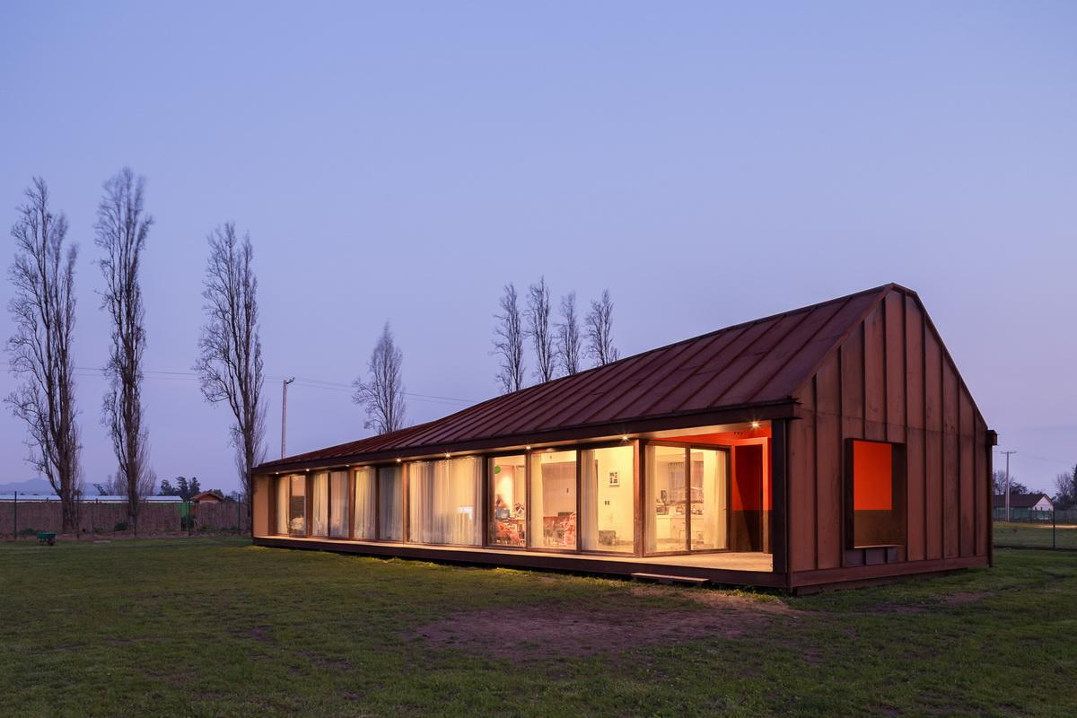 乡村草地上的红色棚屋：PH2住宅 / DX Arquitectos