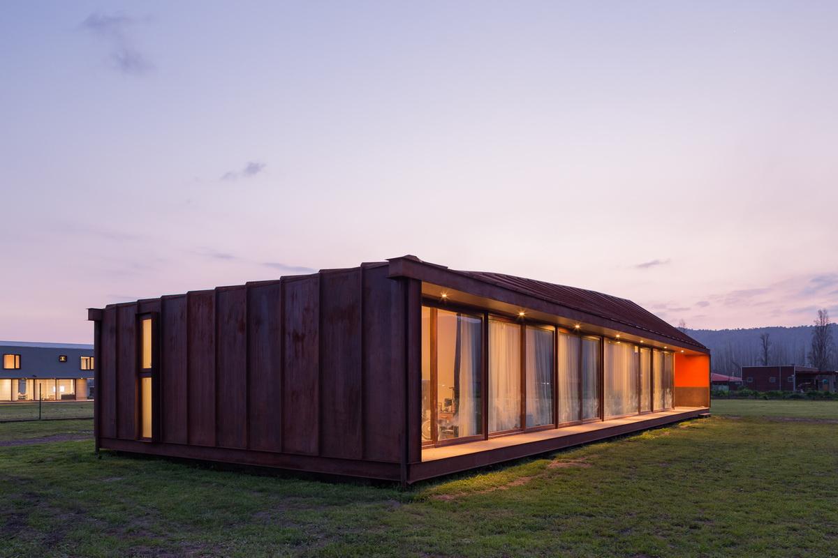 乡村草地上的红色棚屋：PH2住宅 / DX Arquitectos
