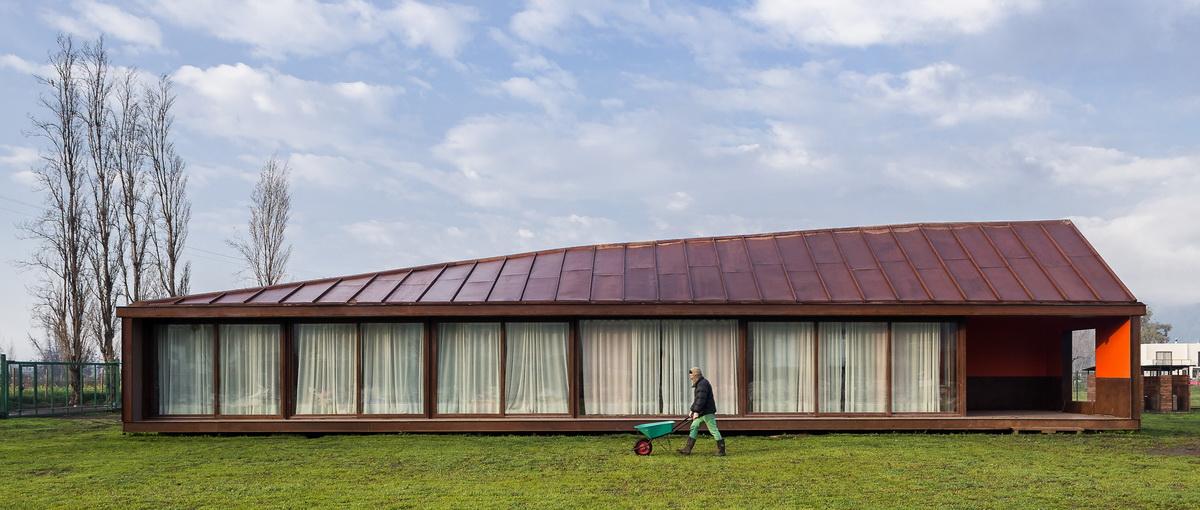 乡村草地上的红色棚屋：PH2住宅 / DX Arquitectos