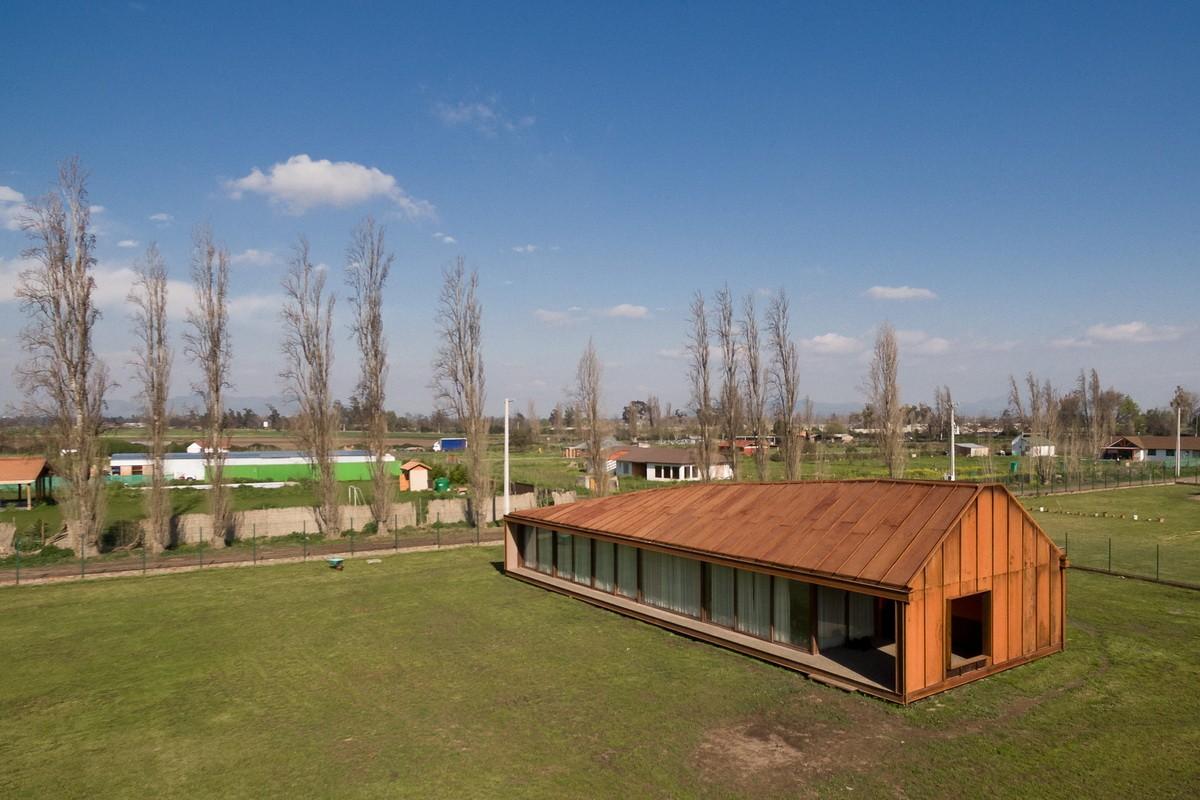 乡村草地上的红色棚屋：PH2住宅 / DX Arquitectos